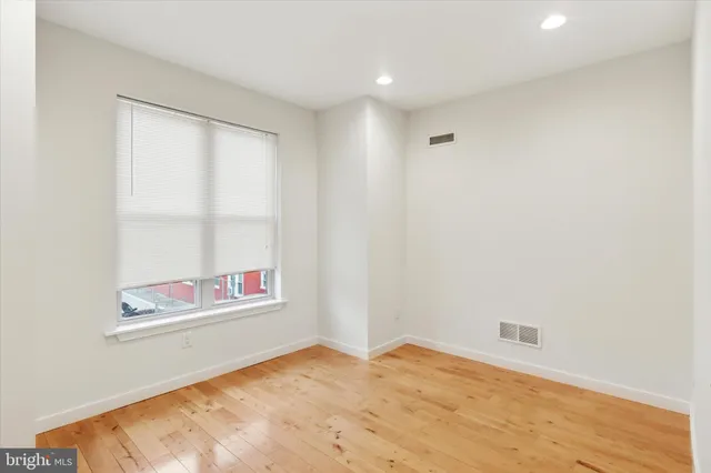 an empty room with ceiling fan and window