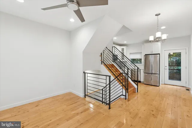 a view of a livingroom with a staircase and ceiling fan