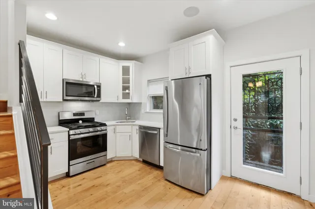 a kitchen with stainless steel appliances granite countertop a refrigerator stove and microwave