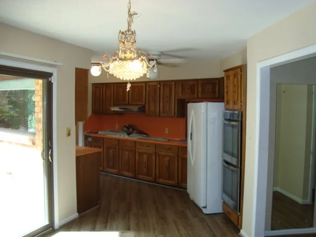 a kitchen with granite countertop a refrigerator and a sink