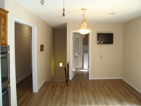 a view of a livingroom with a chandelier fan and windows