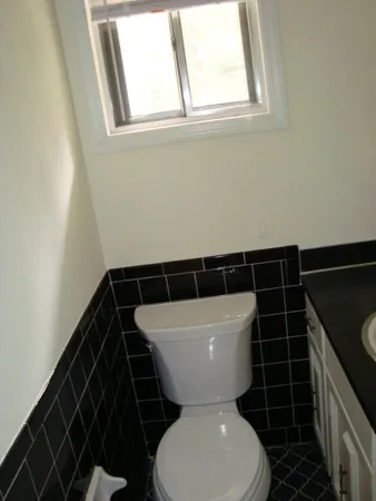 a bathroom with a toilet a sink and a window