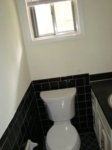 a bathroom with a toilet a sink and a window