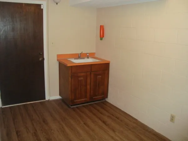 a room with wooden floor and mirror