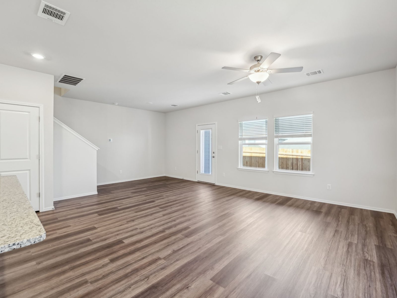165 Calcite Road, Unit 4 Kyle, TX 78640 - Photo 5 of 17 a view of an empty room with wooden floor and a ceiling fan