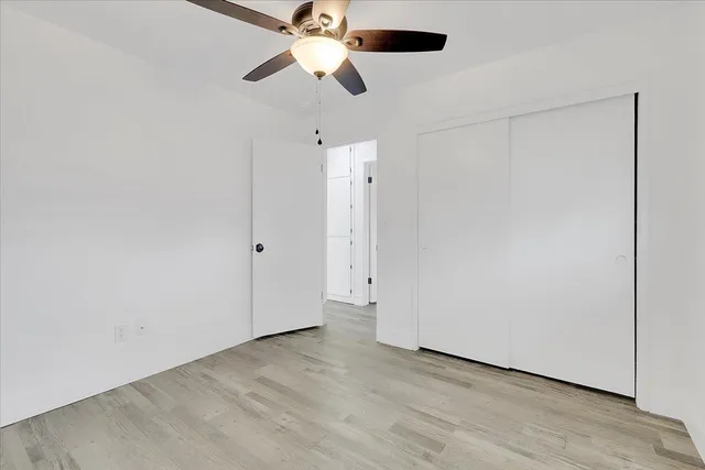 an empty room with a ceiling fan and a fan