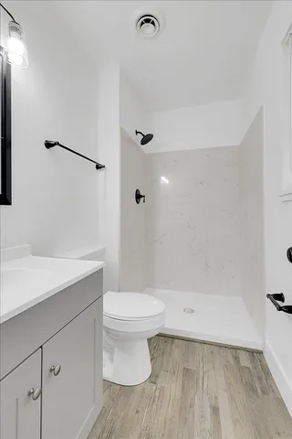 a bathroom with a sink a toilet and shower