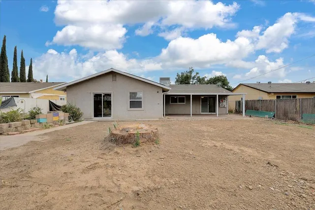 a view of a house with backyard and sitting area