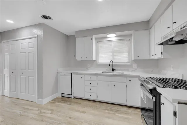 a kitchen with granite countertop white cabinets and white appliances
