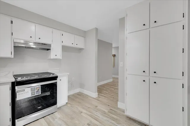 a kitchen with white cabinets and appliances