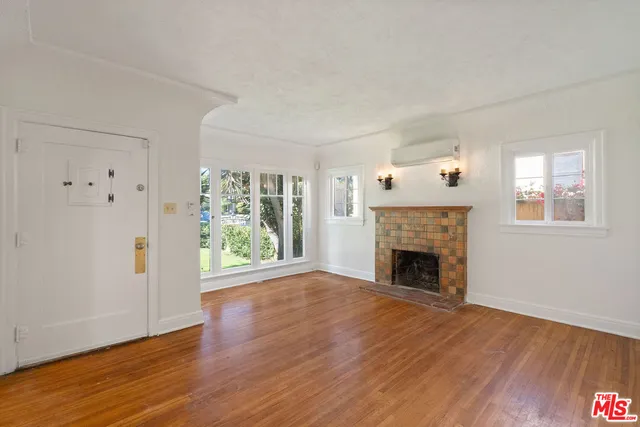 wooden floor fireplace and windows in an empty room
