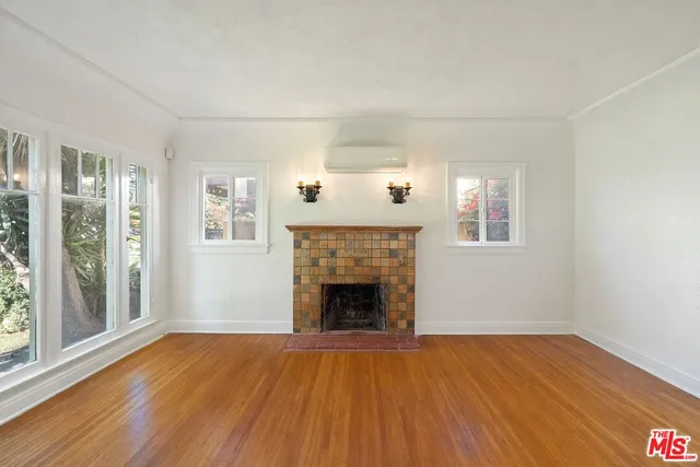 wooden floor fireplace and windows in an empty room