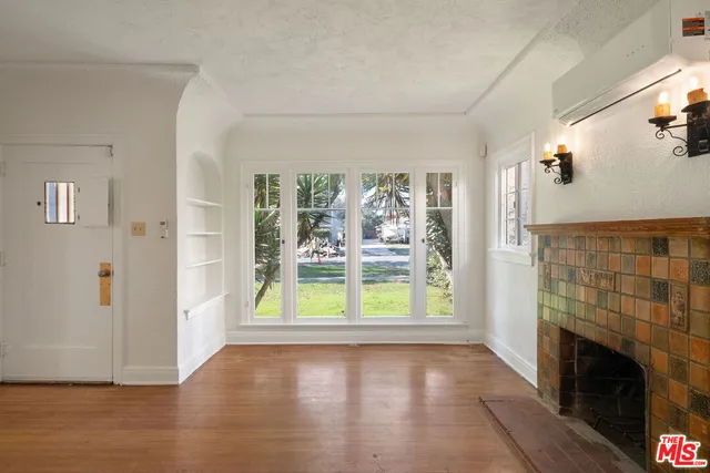 a view of empty room with fireplace and wooden floor