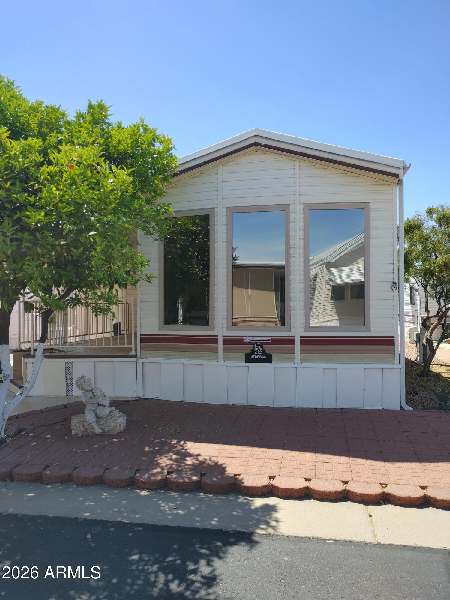 7750 East Broadway Road, Unit LOT 212 Mesa, AZ 85208 - Photo 1 of 12 a front view of a house with a yard