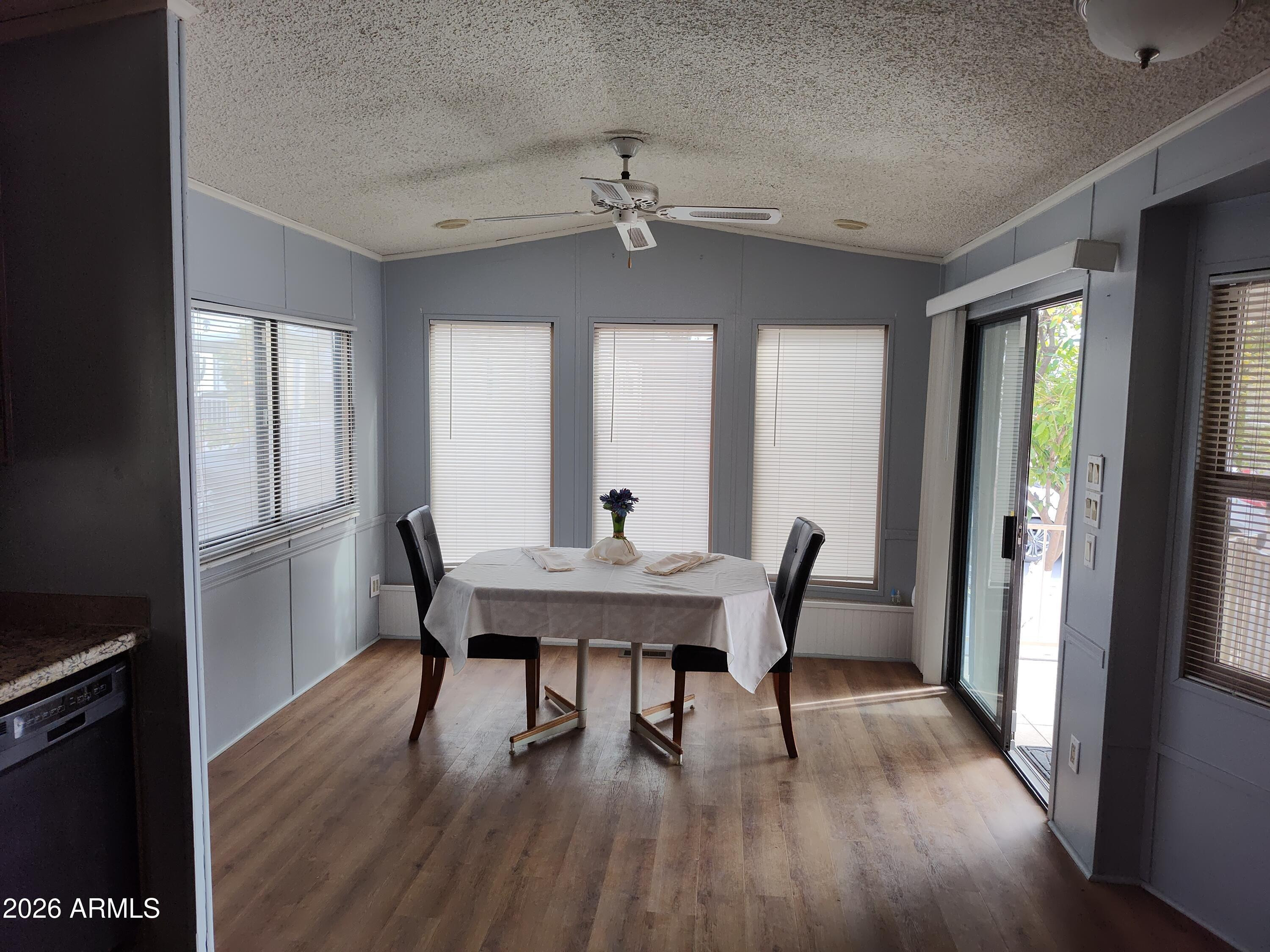 7750 East Broadway Road, Unit LOT 212 Mesa, AZ 85208 - Photo 2 of 12 a view of a dining room with furniture window and wooden floor