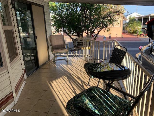 7750 East Broadway Road, Unit LOT 212 Mesa, AZ 85208 - Photo 9 of 12 a view of a patio with table and chairs with wooden floor and fence