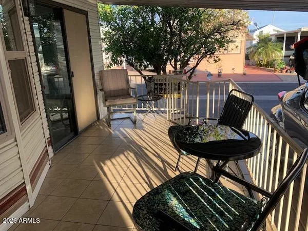 a view of a patio with table and chairs with wooden floor and fence