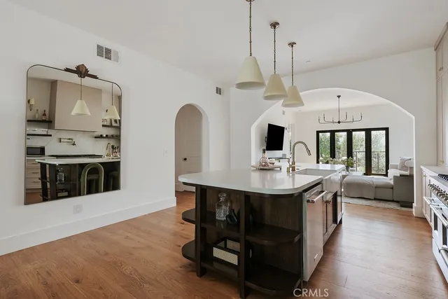 a kitchen with stainless steel appliances kitchen island granite countertop a table chairs in it and white cabinets