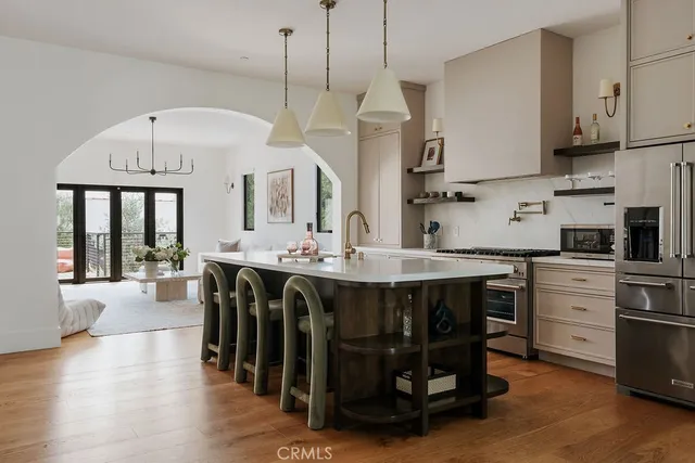 a kitchen with stainless steel appliances a dining table chairs stove and cabinets