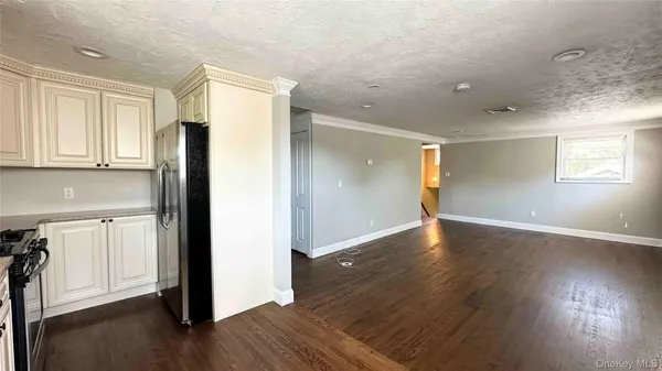 a view of a kitchen with wooden floor and a refrigerator