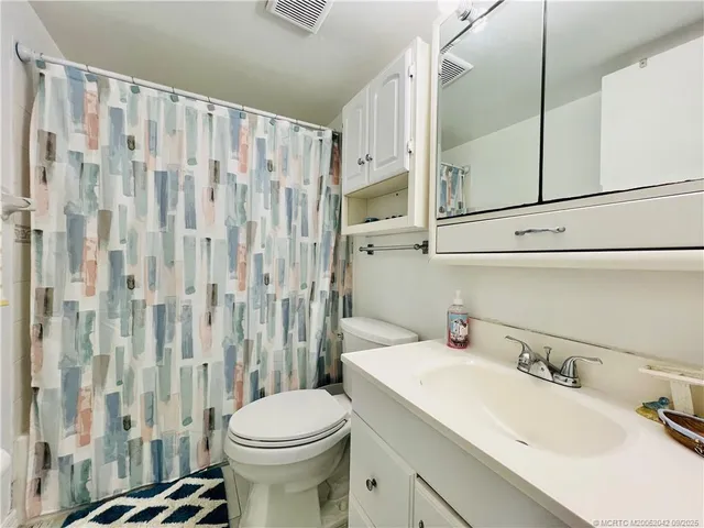 a bathroom with a sink a toilet and shower curtain