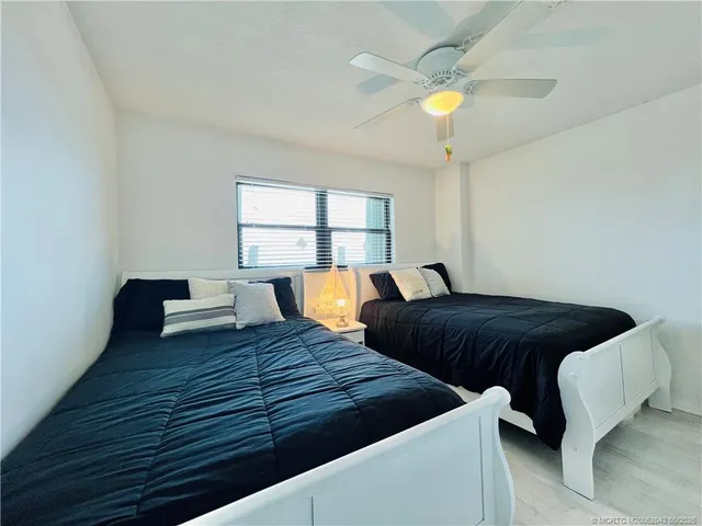 a bedroom with two beds and painting on the wall