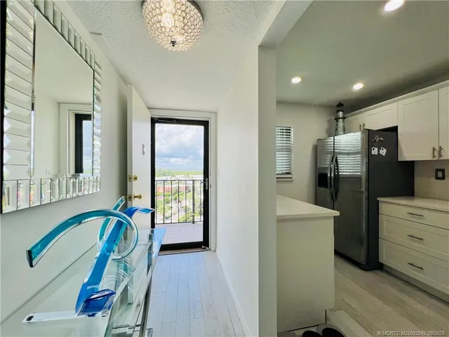 a view of a hallway with furniture and a chandelier