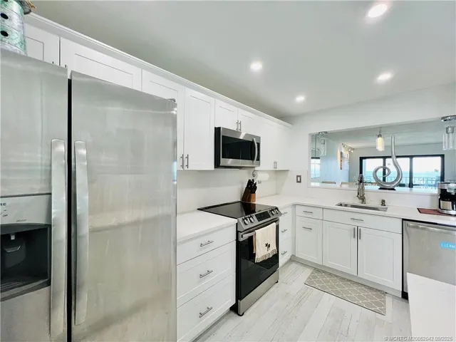 a kitchen with a sink stainless steel appliances and cabinets