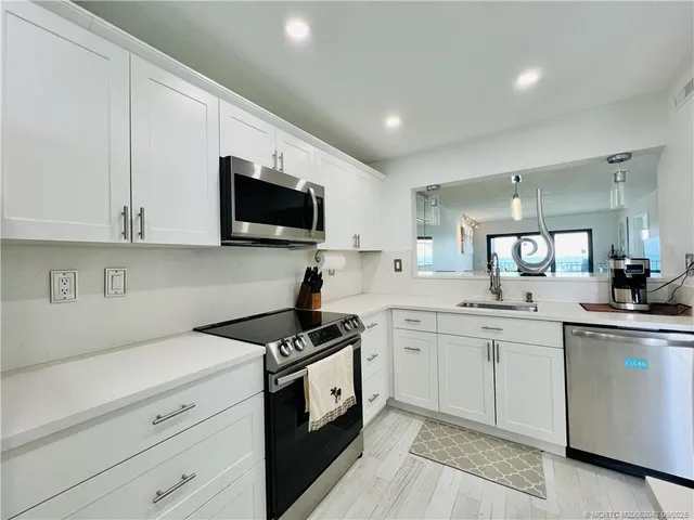 a kitchen with a sink stove and microwave