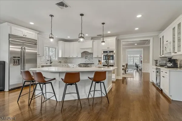 a kitchen with kitchen island granite countertop a stove oven and white cabinets