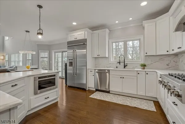 a large kitchen with kitchen island a sink stainless steel appliances and cabinets