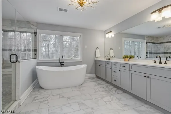 a bathroom with a granite countertop sink a toilet a mirror and shower