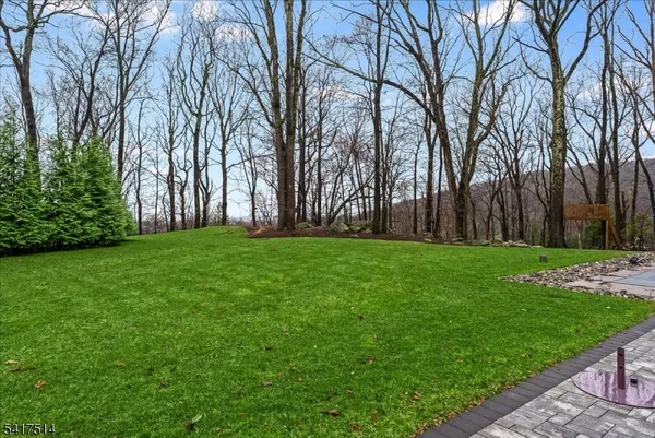 a view of backyard with swimming pool and trees