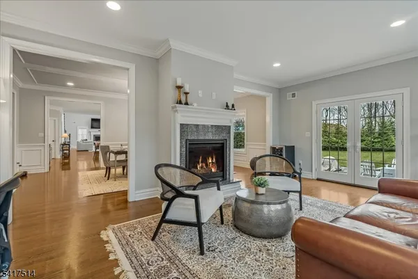 a kitchen with stainless steel appliances kitchen island granite countertop a stove top oven a sink a dining table and chairs with wooden floor