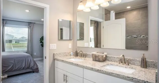 a bathroom with a granite countertop sink double vanity and a mirror