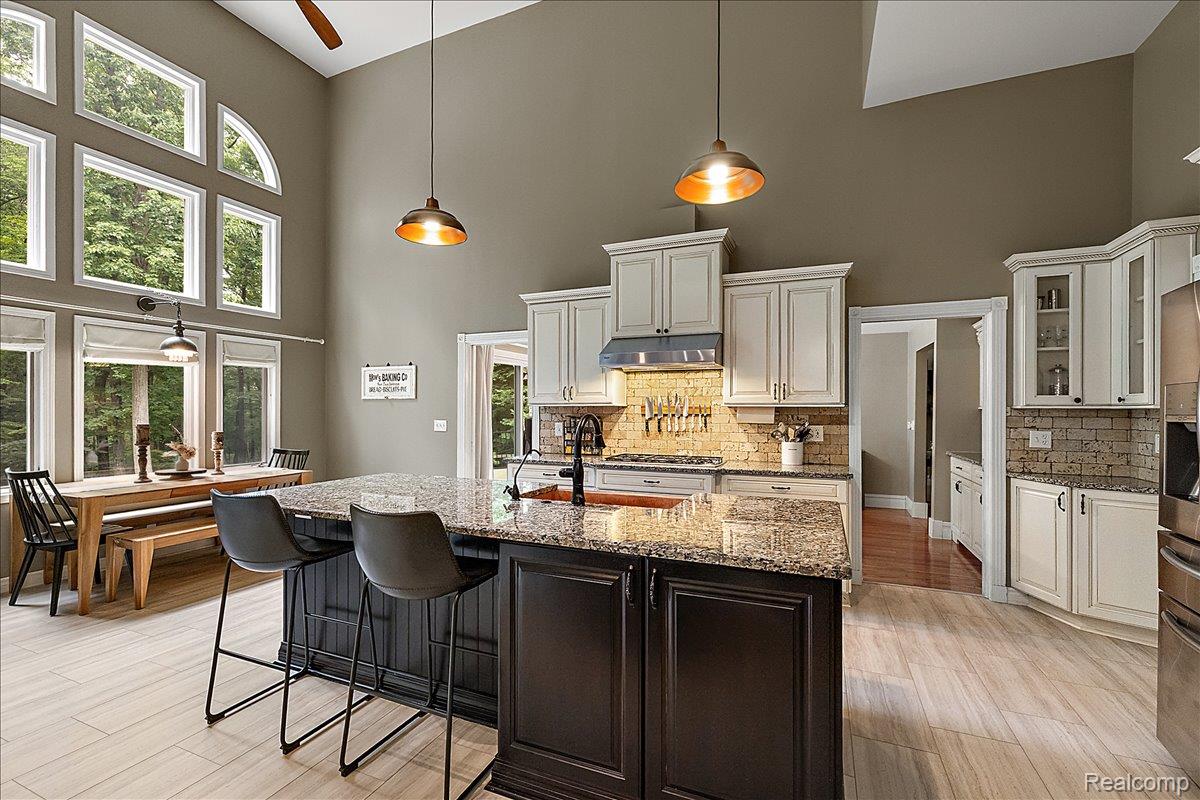 4219 Gardner Road Metamora, MI 48455 - Photo 3 of 84 Spacious kitchen featuring a large central island with a granite countertop, light-toned cabinetry, and wood-finish flooring