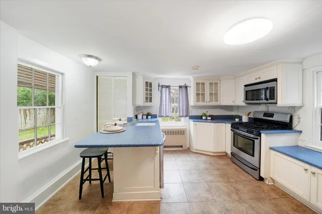 a kitchen with stainless steel appliances kitchen island granite countertop a stove a sink and a refrigerator