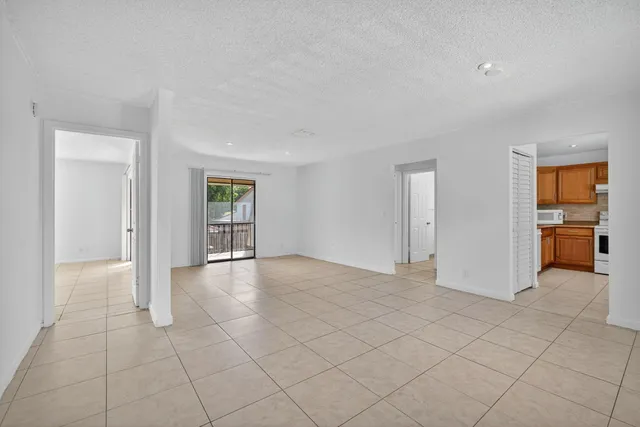 a view of a livingroom with an empty space and a kitchen