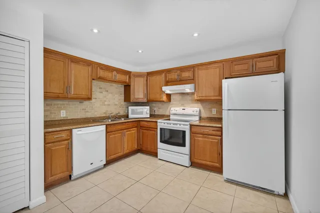 a kitchen with white cabinets and white appliances