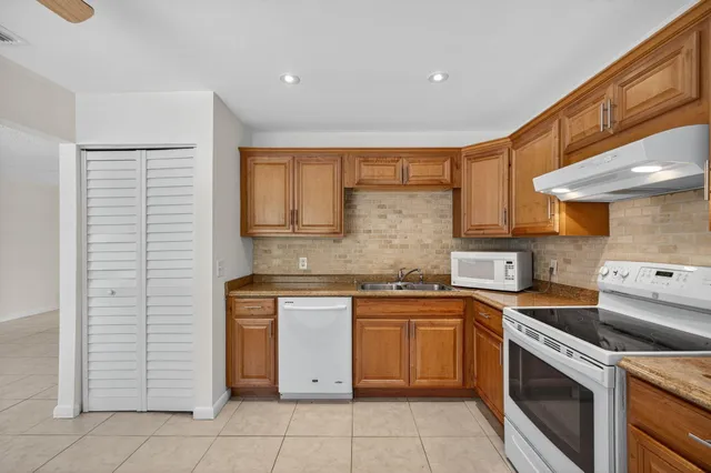 a kitchen with a stove sink and cabinets
