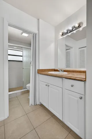 a spacious bathroom with a granite countertop sink and a mirror