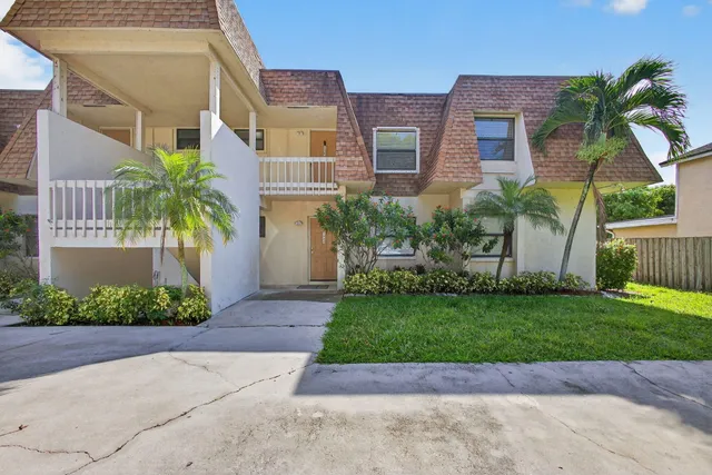 a front view of a house with a garden and yard
