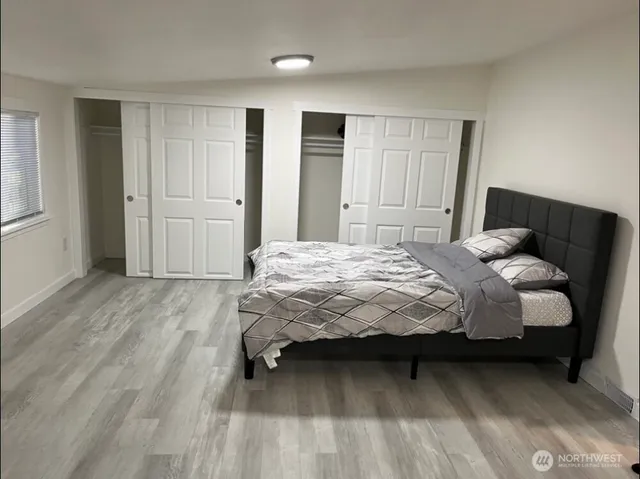 a bedroom with a bed and wooden floor