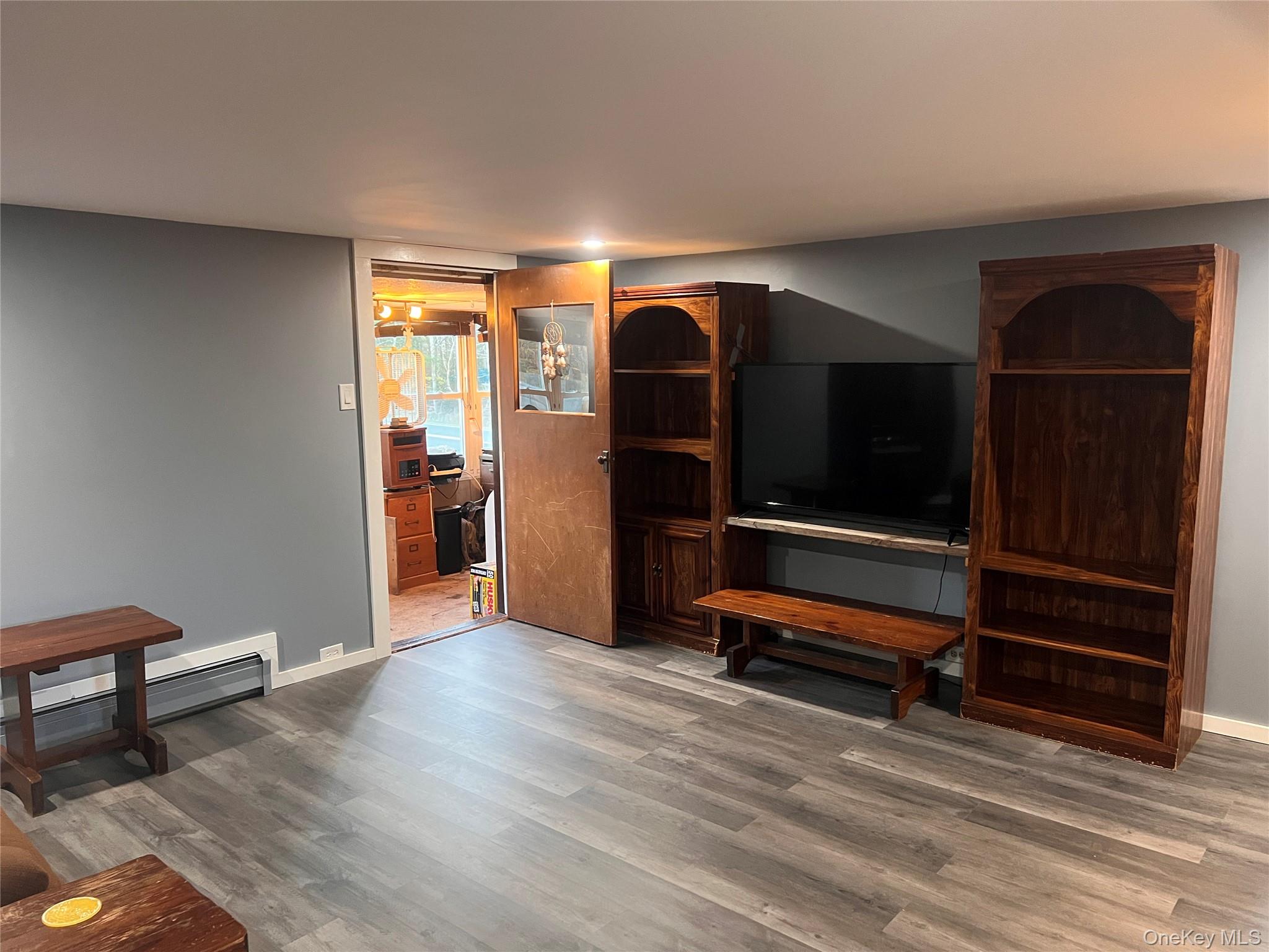 279 Cold Spring Road Monticello, NY 12701 - Photo 8 of 32 Living room with wood finished floors and a baseboard radiator