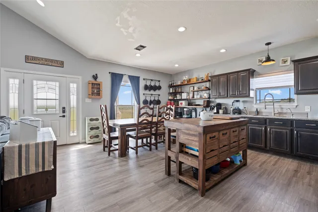 a kitchen with stainless steel appliances a table chairs and a refrigerator