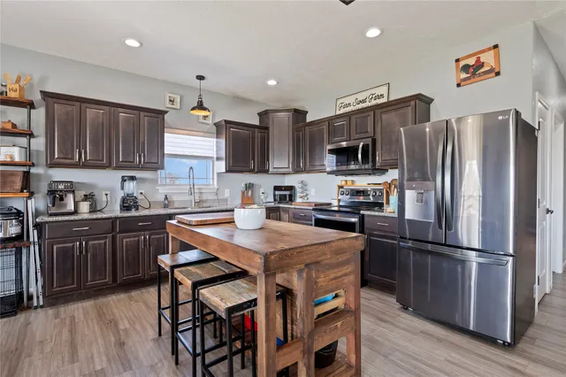 a kitchen with stainless steel appliances granite countertop a stove and a refrigerator with white cabinets