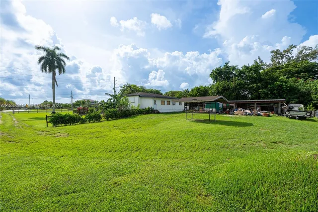 a view of a house with a big yard and potted plants