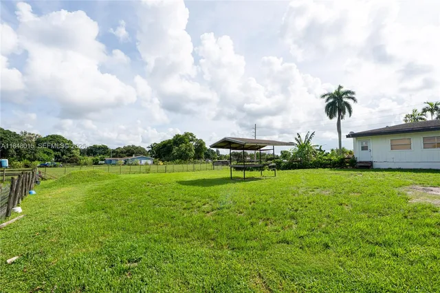 a view of a house with a big yard and a large trees