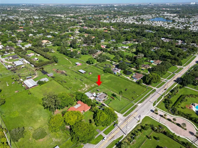 an aerial view of residential houses with outdoor space and trees