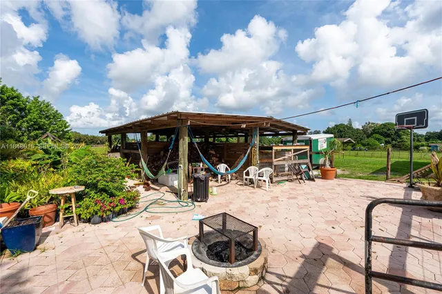 a view of a patio with table and chairs under an umbrella